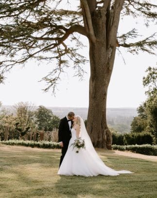 Bride and groom kissing on the grounds of Hedsor House