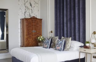 The Alexander suite showing a bed and wardrobe with a navy and white colour scheme