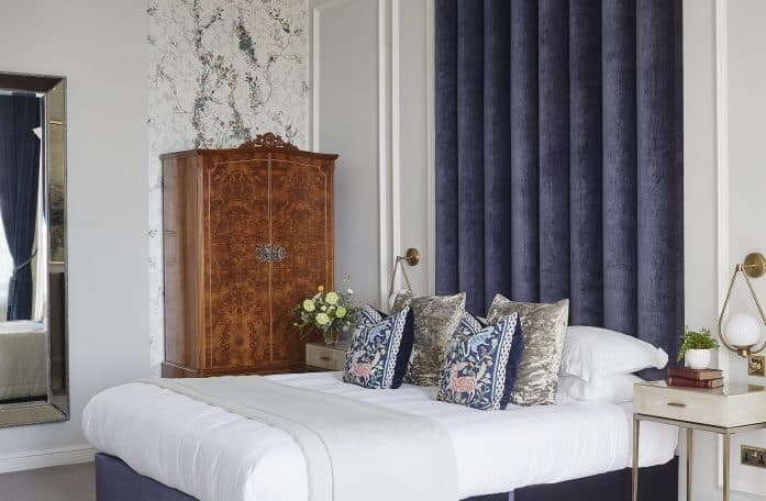 The Alexander suite showing a bed and wardrobe with a navy and white colour scheme