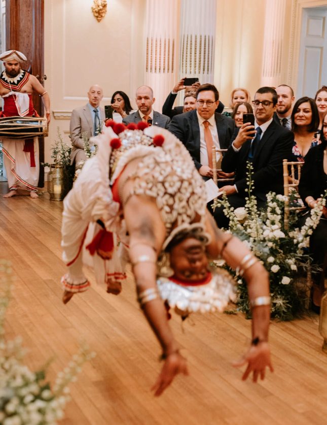 Guest performing a backflip at a South Asian wedding entrance